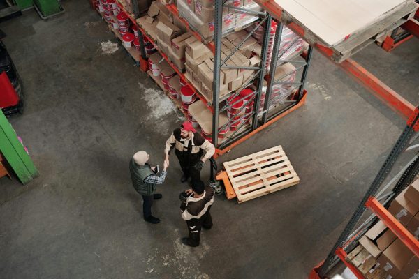 High angle view of workers discussing logistics in a warehouse setting.