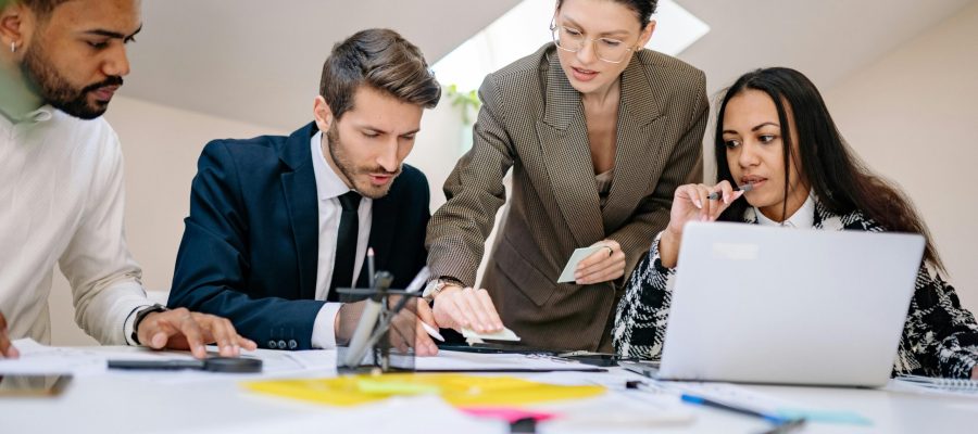 Business team working together at desk with documents and laptop in a contemporary office.